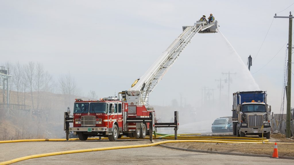 Firefighters work to put out a fire in a south-east industrial park on 52 Street near Erinwoods in Calgary on Wednesday, April 5, 2017. The fire affected power lines and some vehicles, causing black smoke to fill up the air for a while. (Photo by Chelsey Harms/660 NEWS)